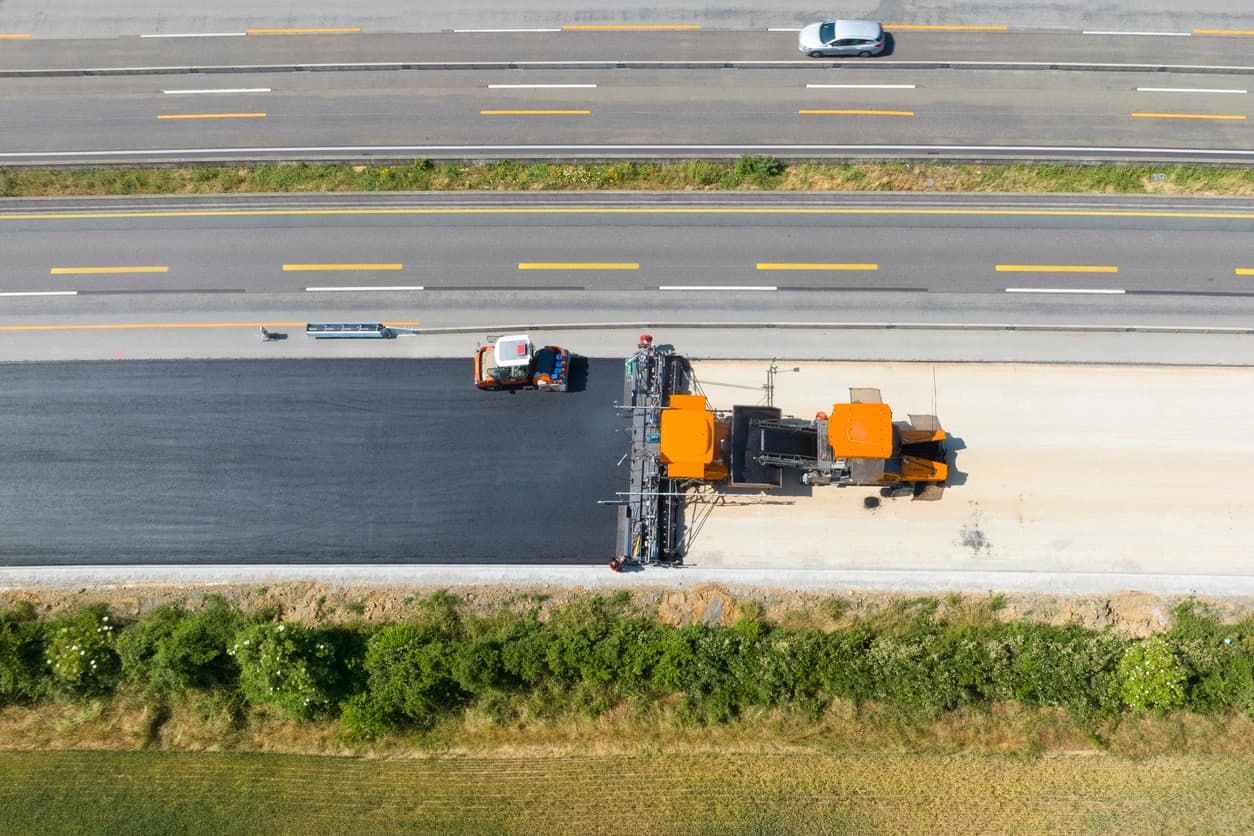 Aerial view of asphalt paving equipment working on highway construction